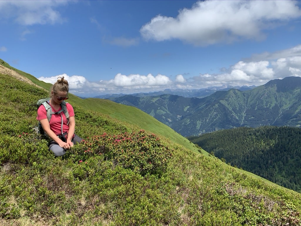 Linda betrachtet Blumen auf dem Weg zur Biberalm