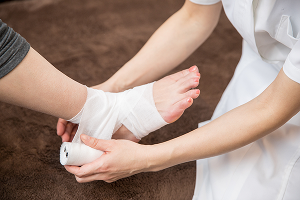 Fuss wird von Ärztin bandagiert