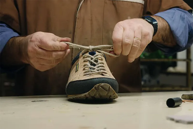 barfuß wanderschuh bekommt seine schnürsenkel eingezogen