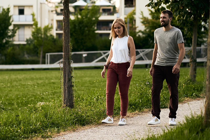 pärchen läuft mit weißen barfußschuhen im park