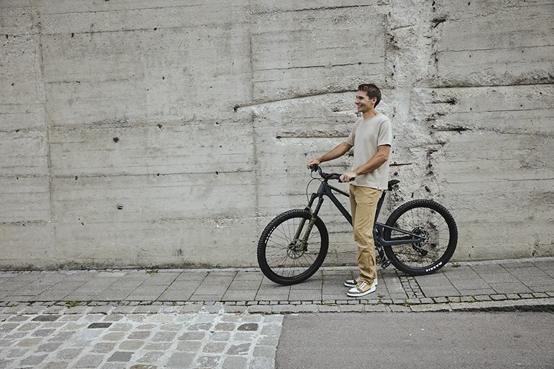 herr mit nachhaltigen sneakern und fahrrad